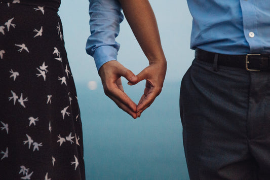 Two people's hands together forming a heart, symbolising connection and kindness.