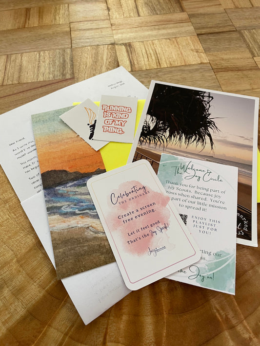 inclusions for the august edition of mailbox magic. A photograph postcard, a bookmark, stickers, the joy circle card, joy spark card and letter all delivered in a bright coloured envelope.
